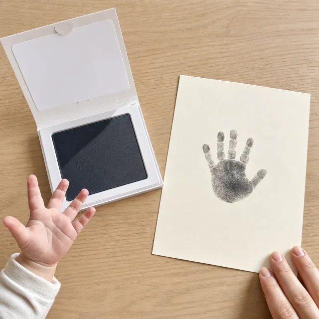 Clean inkless print pad and neat baby handprint on white paper with no paint mess